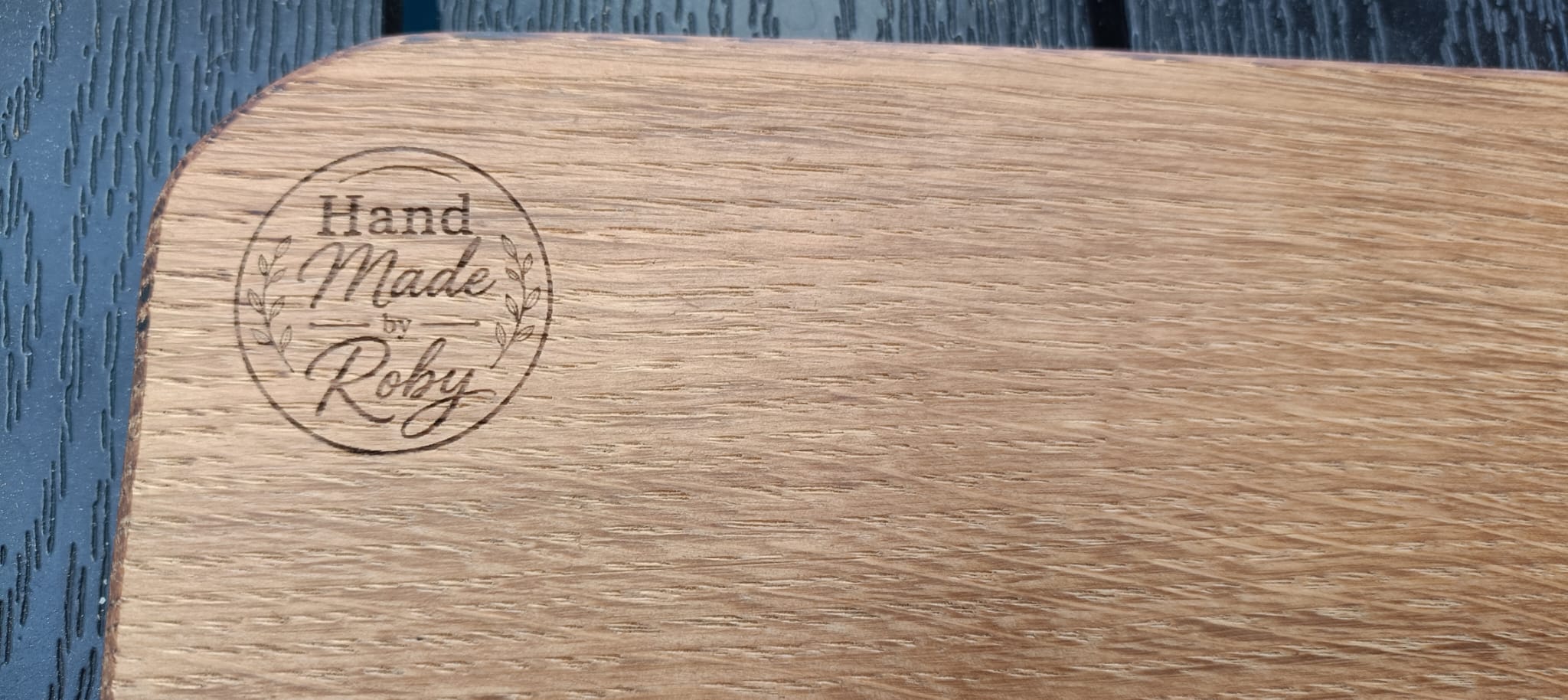 Dettaglio del logo Hand Made by Roby inciso nel legno