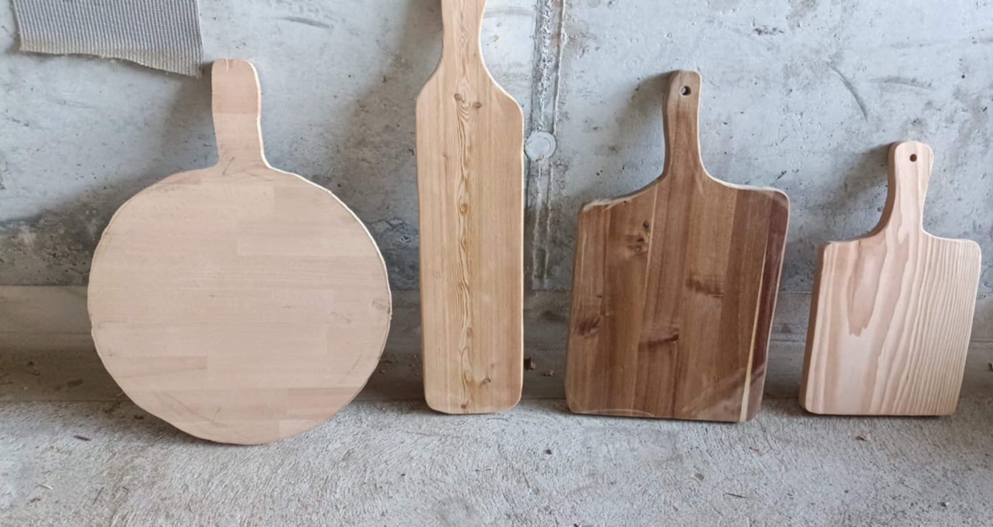 Quattro forme diverse di taglieri grezzi appoggiate in bottega